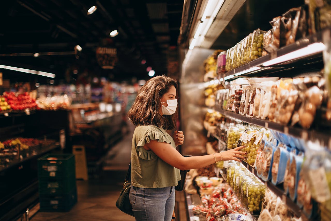 Mujer seleccionando productos en góndola de supermercado